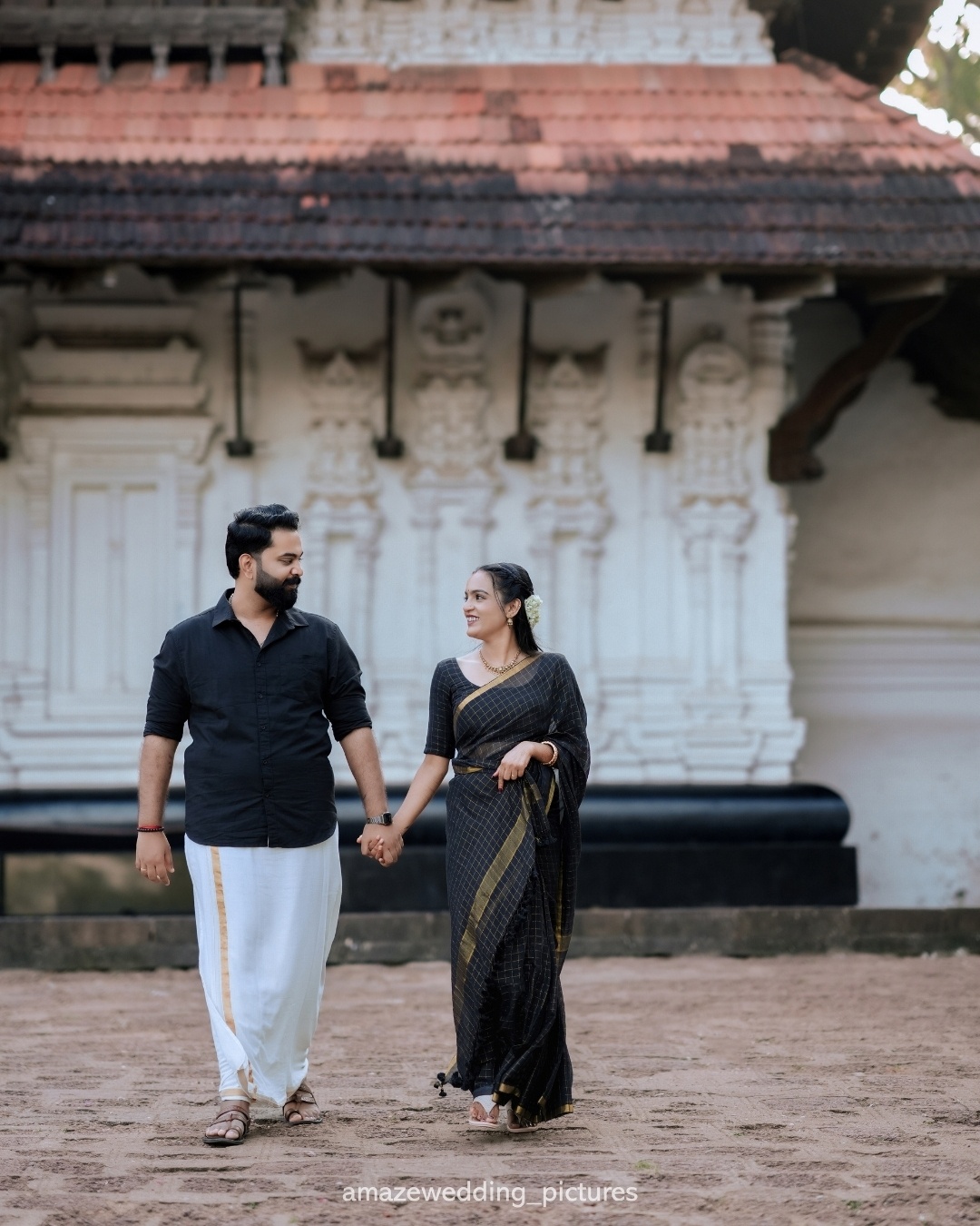A couple walking together beside a heritage building